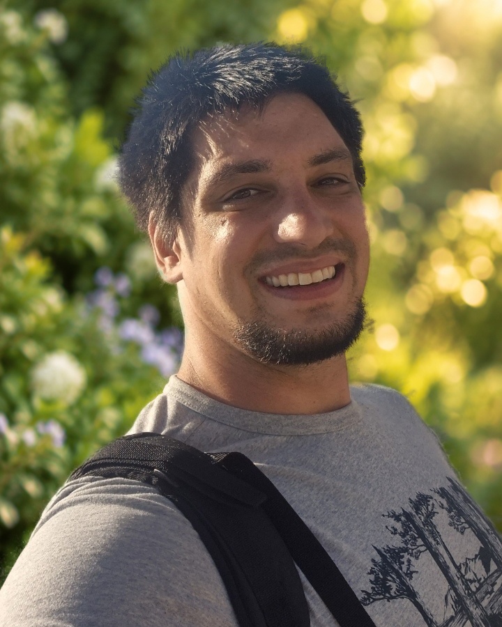 Kevin Geiser, Geschäftsführer von Geiser Gartenbau, vor einer grünen Gartenhecke